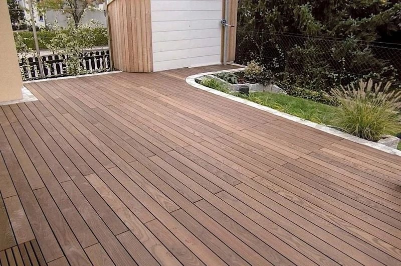 Thermally modified ash deck beside a garden