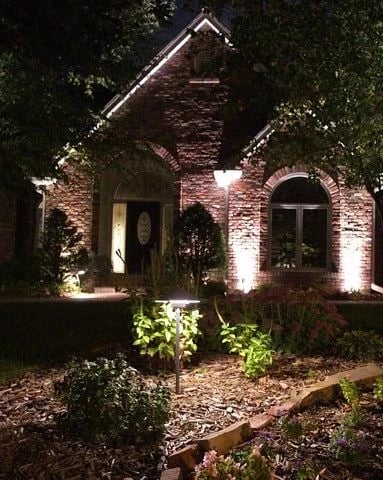 Brick entry and gable lit by ground uplights