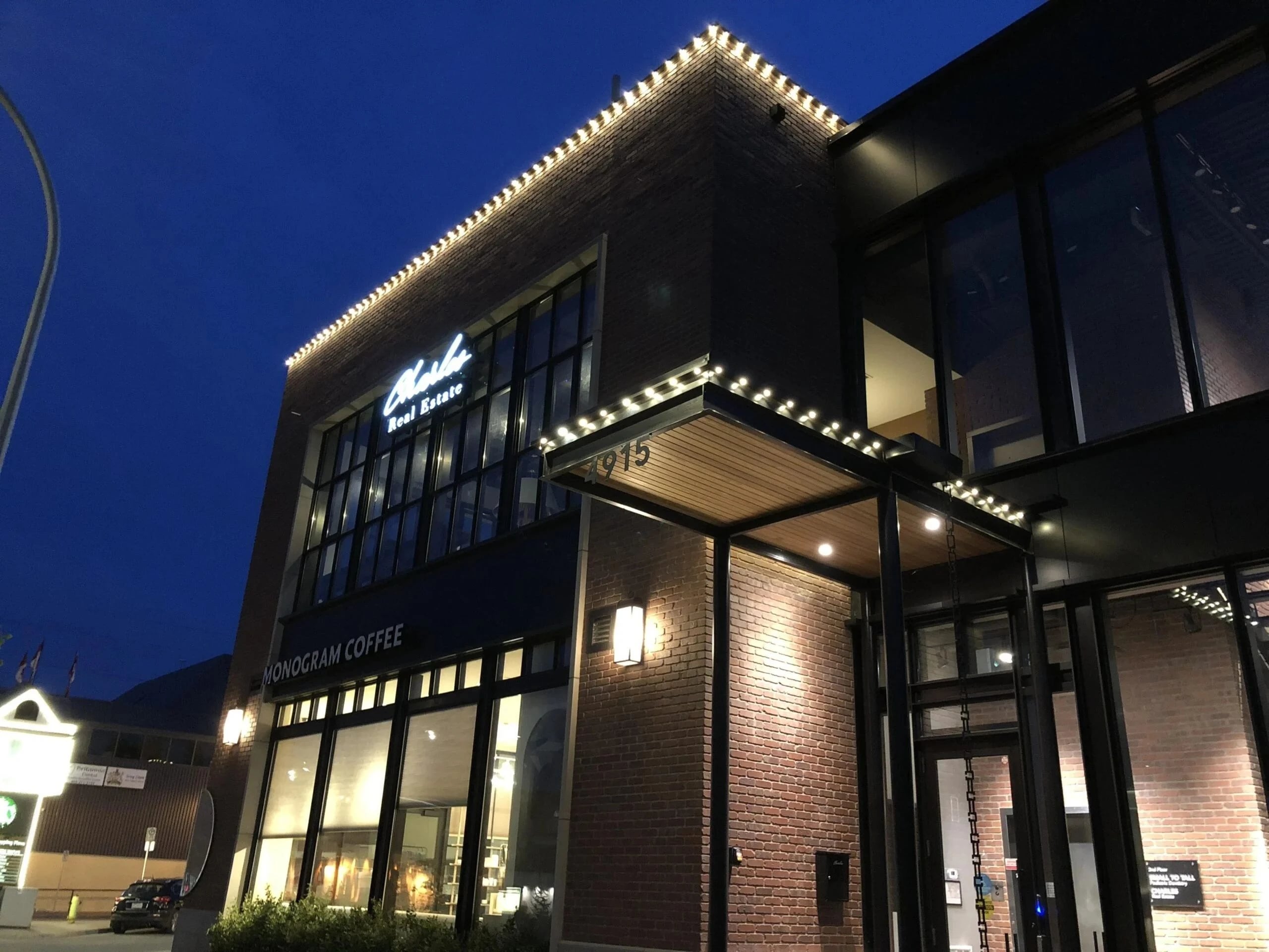 Commercial building outlined in permanent roofline lighting at night