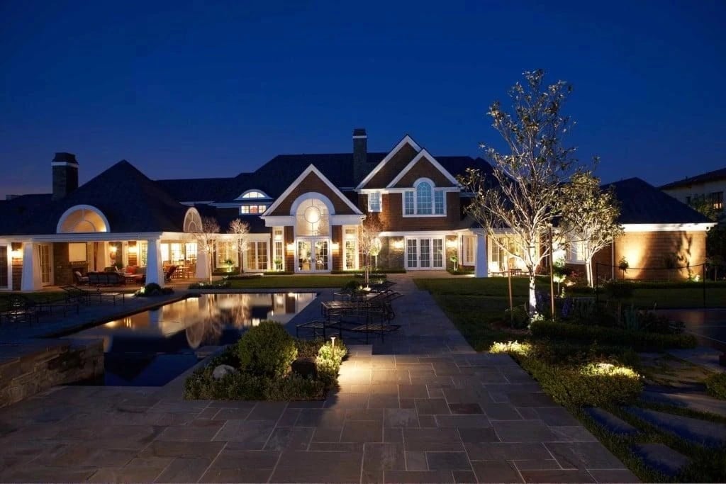 Home, pool, and walkway lit at dusk