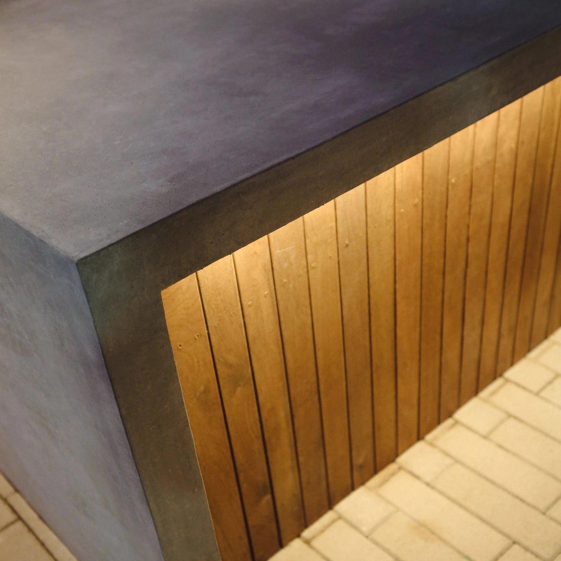 LED strip lighting tucked under a concrete wall cap