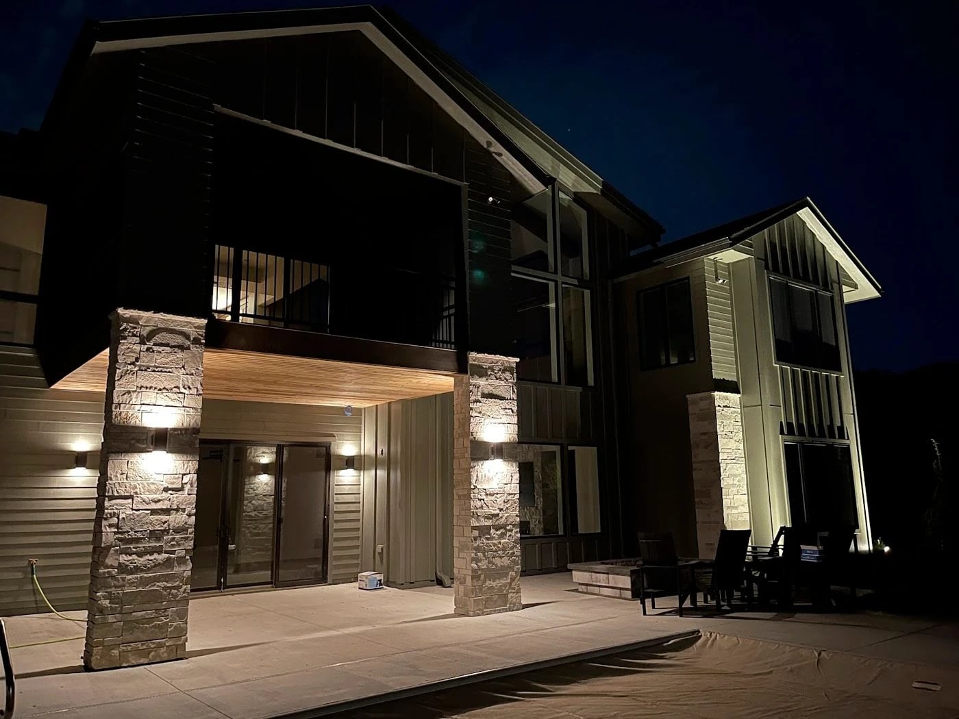 Modern home with warm sconce and soffit lighting at night